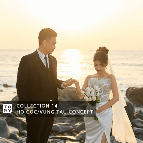 Cặp đôi cưới cân bằng trên những tảng đá dẫn ra biển, ánh mặt trời chiều tạo bóng dạ kỳ trên mặt đất, nước biển xanh phía sau tạo nên bức ảnh lãng mạn
