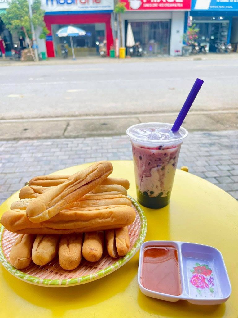 Bánh mì cay nóng hổi từ lò nướng, với nhân pate, xúc xích, hành phi và ớt cay đặc trưng - nguồn từ iVIVU Blog