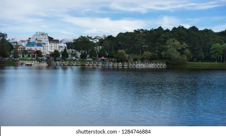 Hồ Xuân Hương Đà Lạt lúc hoàng hôn với hàng thông xanh phản chiếu xuống mặt nước